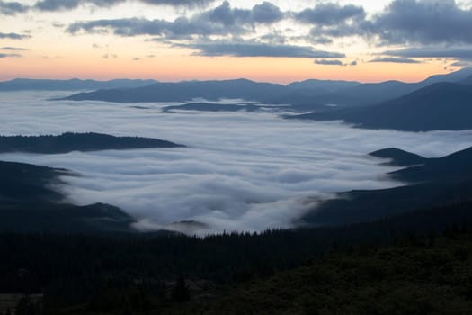 Sunrise in the mountains above the clouds