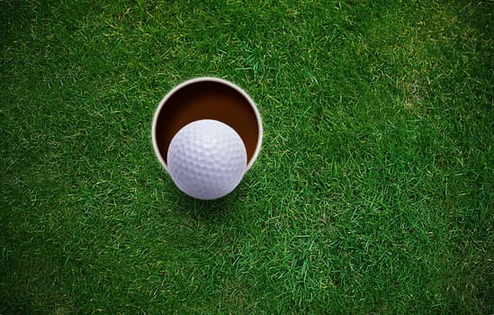 golf ball on lip of hole .