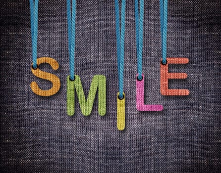 Smile Letters hanging strings with blue sackcloth background.