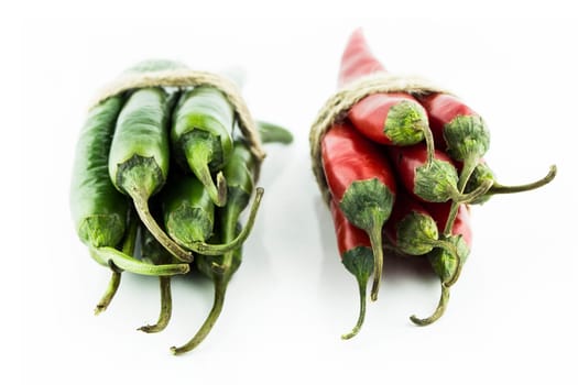 Two sets of red and green hot chili pepper on a white background