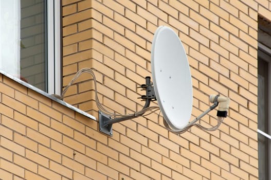Antenna on wall near the window. Brick wall