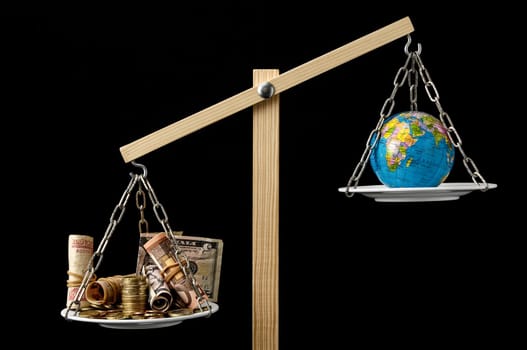 Globe Planet Earth and Money on a Two Pan Balance