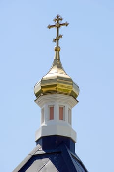 Golden dome of the Orthodox church in Optina hermitage on the blue sky background