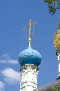 Golden dome of the Orthodox church in Optina hermitage on the blue sky background