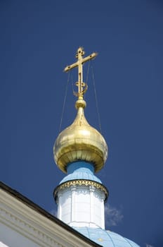 Golden dome of the Orthodox church in Optina hermitage on the blue sky background