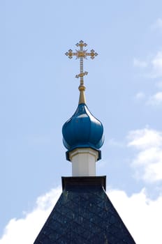 Golden dome of the Orthodox church in Optina hermitage on the blue sky background