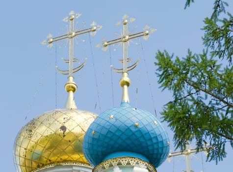 Golden dome of the Orthodox church in Optina hermitage on the blue sky background