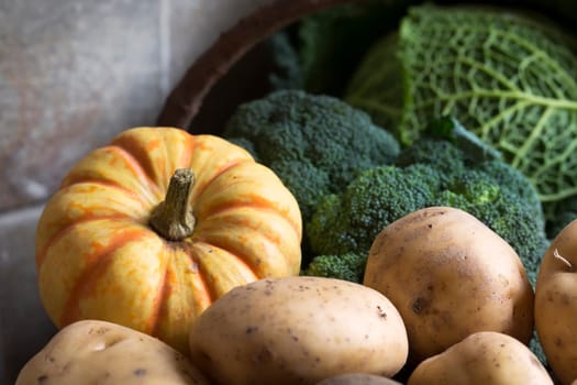 Basket of winter vegetables including broccoli, sweet lightning squash and potatoes.