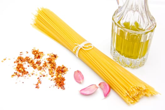 Spaghetti with garlic, oil and chilli peppers on white background