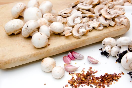Mushrooms on cutting board on white background