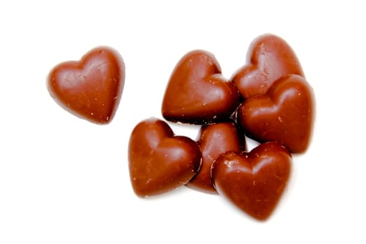 Chocolate hearts arranged on white background