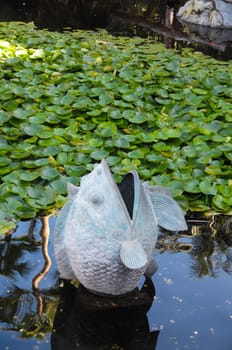 Metal Fish Statue on a Dark Pond