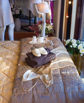 White female slippers on the towels in the bed