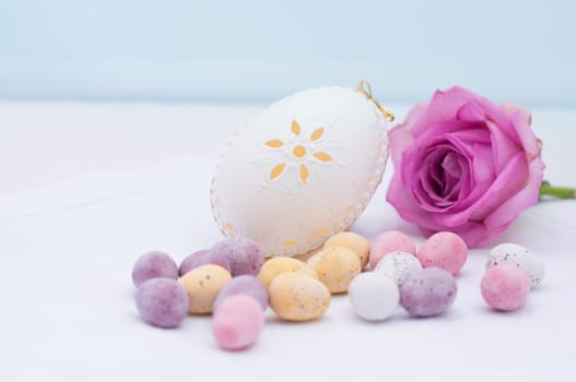 small colorful Easter eggs on a white background,decorated with a rose