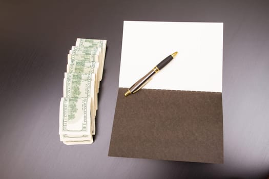 Lots of dollars with an open copybook.