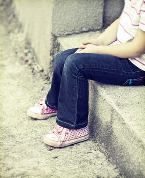 Vintage photo of lonley girl sitting in the schoolyard