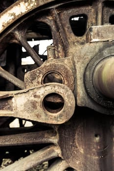 A fragment of an old damaged and rusty steam engine, old style type locomotive, vertical frame.