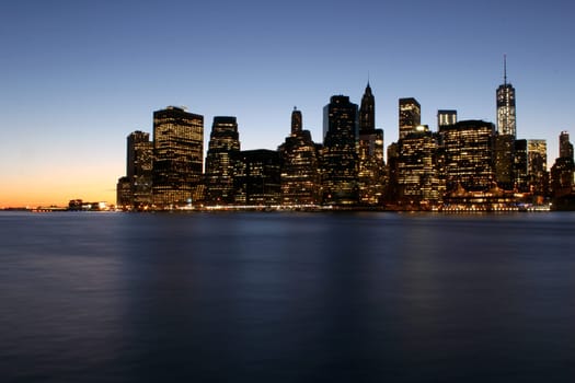 Twilight as the sun sets over Lower Manhattan. Famous New York landmarks.