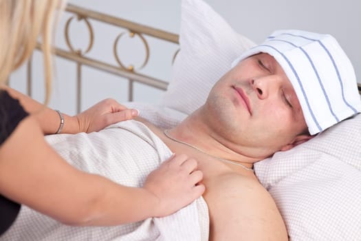 woman caring for sick man on the bed