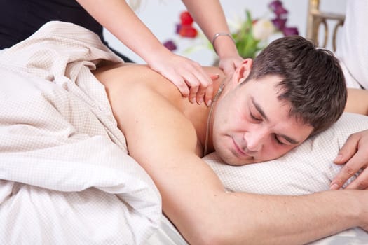 Man receiving domestic massage on bed
