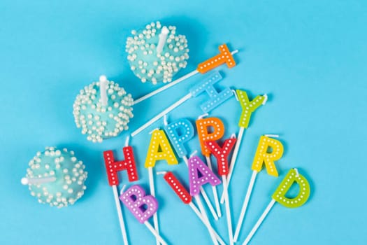 Cakes with rainbow-colored birthday candles with the inscription "Happy Birthday"