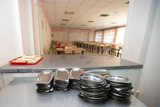 Iron plates in the background of a public dining room.School breakfast in a Russian school