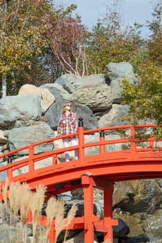 Woman in red plaid shirt enjoying nature walking in Japanese Garden