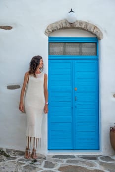 Woman in white dress next to an old blue door
