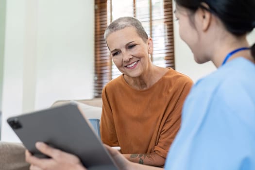 Asian nurse showing health checkup report to older and giving advice. Home nursing and healthcare caregiver concept.