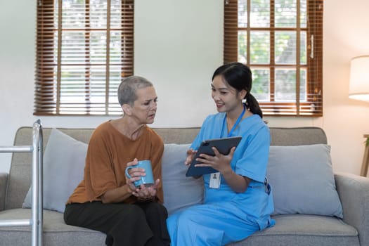 Asian nurse showing health checkup report to older and giving advice. Home nursing and healthcare caregiver concept.