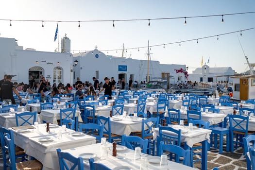 Restaurant tables prepared for dinner in the port of Naoussa, Paros, Greece