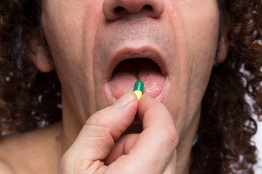 Cropped portrait of mediterranean looking man taking medicine pill