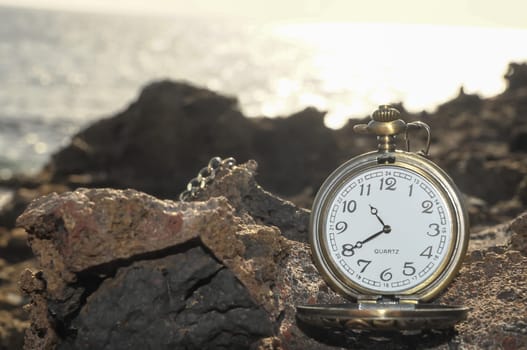 Time Concept Classic Vintage Pocket Clock on the Volcanic Rocks