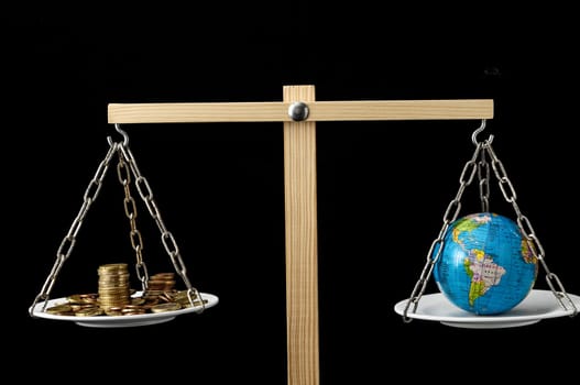 Globe Planet Earth and Money on a Two Pan Balance