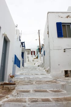 A small alley in the town of Fira on the island of Mykonos Greek with the.copestone street and the white houses..