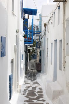 A small alley in the town of Fira on the island of Mykonos Greek with the.copestone street and the white houses..
