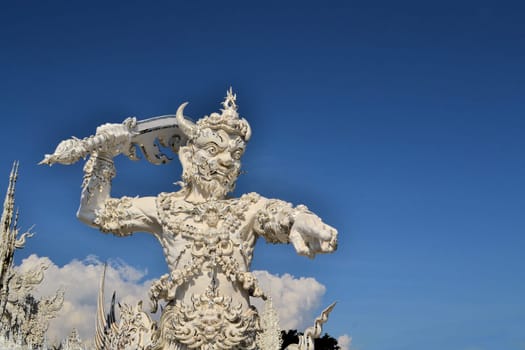 Conceptual sculpture of a demon from Buddhist hell suffering, asking for help at Rongkhun Temple, Chiangrai