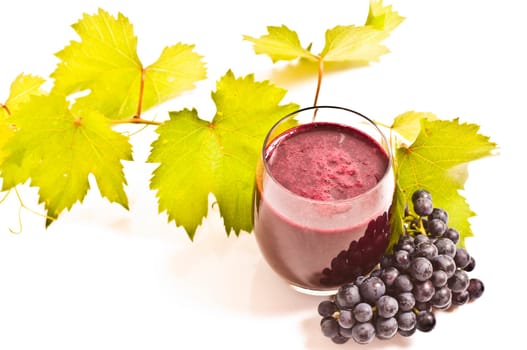 freshly squeezed red grape juice with vine leaves on a white background
