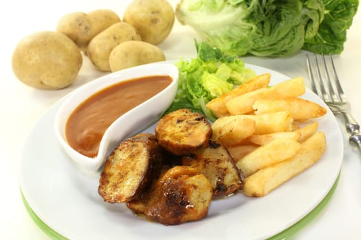 a currywurst with fries and salad