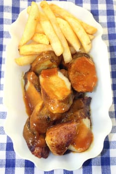 a currywurst with fries and salad