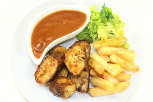 a currywurst with fries and salad