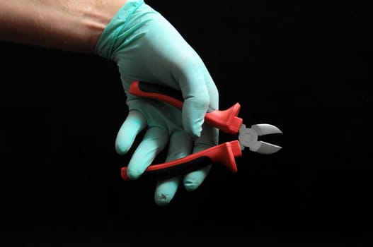 Cutter Pliers and a Hand on Black Background