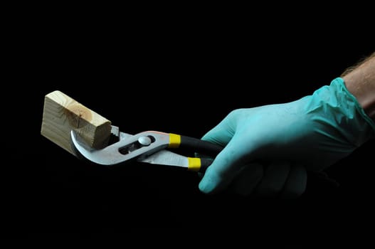 Pliers and Hand on a Black Background