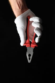 Pliers and Hand on a Black Background