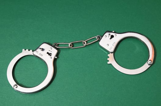 One Pair of Handcuffs on a Colored Background