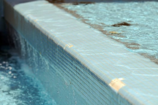Some Water Dropping off a Blue Swimming Pool
