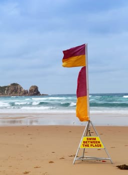 Surf life-saving flags at the beach with warning to swim between the flags