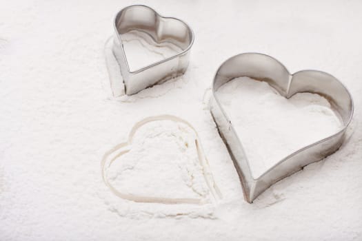 Heart cookie cutters in flour