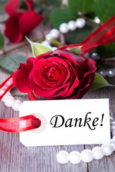 A Background with Rose and Pearls and the German Word Danke Which Means Thanks