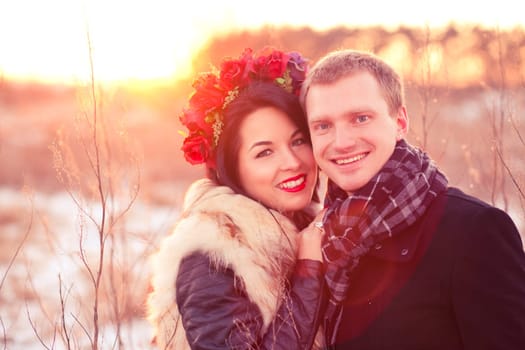 Cheerfull young lovers are smiling and hugging in sunlight